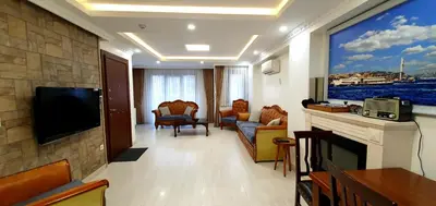 a living room with a flat screen tv and a large window at Taksim Flat in Istanbul