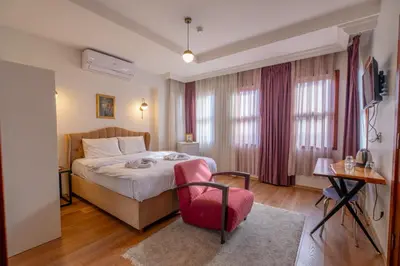 a bedroom with a bed and a red chair at New homes oldcity in Istanbul