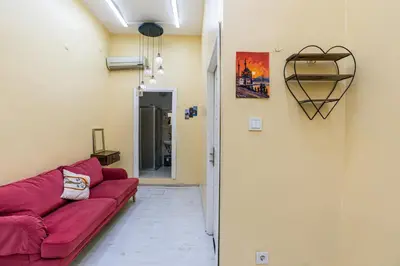 a living room with a red couch and a heart on the wall at Galata Comfortable 12 Suits in Istanbul