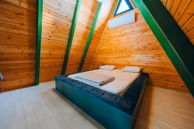 a bed in a room with a wooden wall at 777Sapanca Bungalov Konaklama in Sapanca