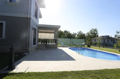 a swimming pool next to a house at Guzel Evler Family Resort in Sapanca