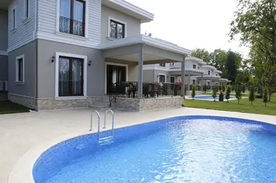 a house with a swimming pool in front of a house at Guzel Evler Family Resort in Sapanca