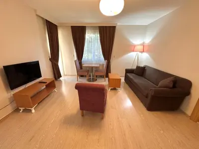 a living room with a couch and a television at Şeker Apartments in Tuzla