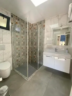 a bathroom with a shower and a toilet and a sink at Kerpe Diem Otel in Kerpe