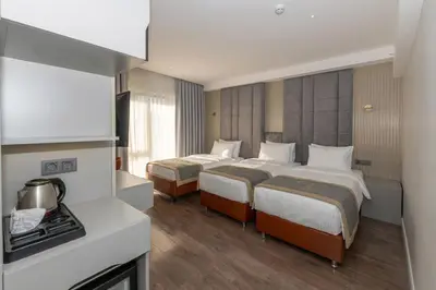 a hotel room with two beds and a stove at Tumar Istanbul Hotel in Istanbul