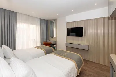 two beds in a hotel room with a flat screen tv at Tumar Istanbul Hotel in Istanbul