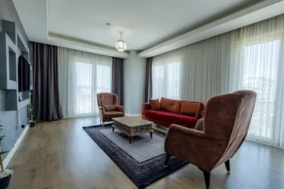 a living room with a red couch and two chairs at My SUİTES in Istanbul