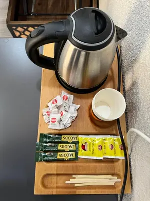 a tea pot sitting on a wooden table with packets of sugar at ergene park hotel