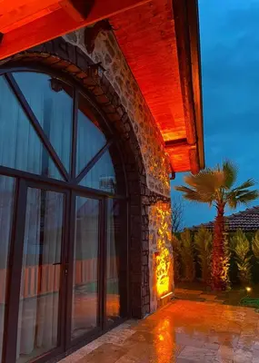 an arched doorway to a house with a palm tree at Taş Devri Konaklama in İznik