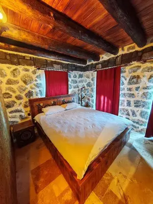 a bedroom with a large bed in a stone room at Taş Devri Konaklama in İznik