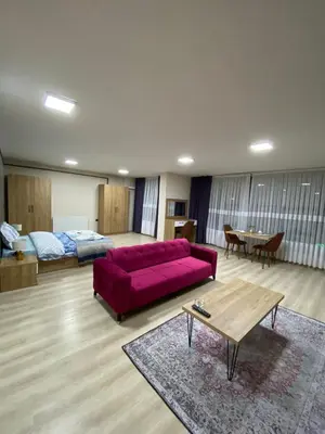 a living room with a red couch and a bed at Luxury Suit