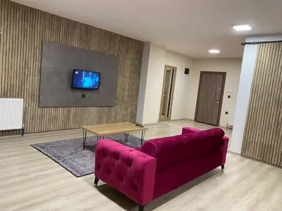 a living room with a red couch and a tv at Luxury Suit