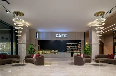 a lobby with couches and tables in a library at Ramada Residences by Wyndham Istanbul Haramidere in Istanbul