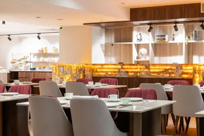 a dining room with tables and chairs and a bar at Ramada Residences by Wyndham Istanbul Haramidere in Istanbul