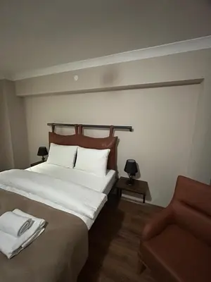 a bedroom with a large white bed and a chair at Pera Line Yalova in Yalova