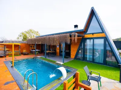 a house with a swimming pool in front of it at Palmera suit in Sapanca