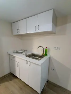 a kitchen with a sink and white cabinets at Do Not Disturb Suites in Istanbul