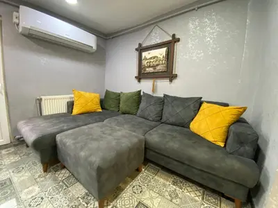 a living room with a gray couch and yellow pillows at Orange Airport Hotel in Istanbul