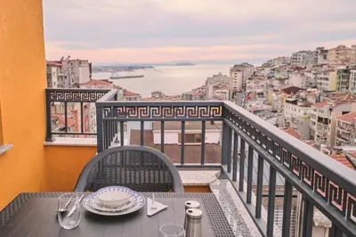 a table on a balcony with a view of a city at Ulker Apartments in Istanbul