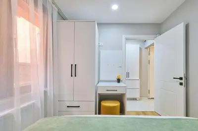 a bedroom with white cabinets and a yellow stool at Ulker Apartments in Istanbul