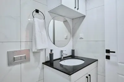 a white bathroom with a sink and a mirror at Ulker Apartments in Istanbul
