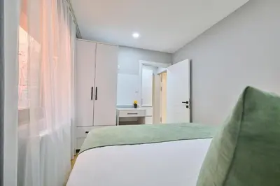 a white bedroom with a bed and a window at Ulker Apartments in Istanbul