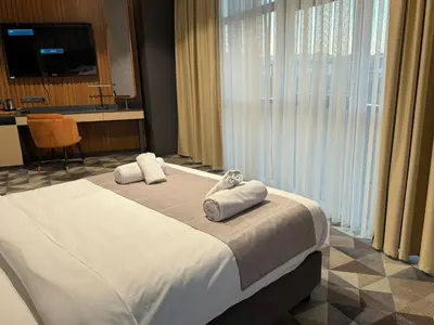 a hotel room with a bed with towels on it at H-mak AIRPORT OTEL in Arnavutköy