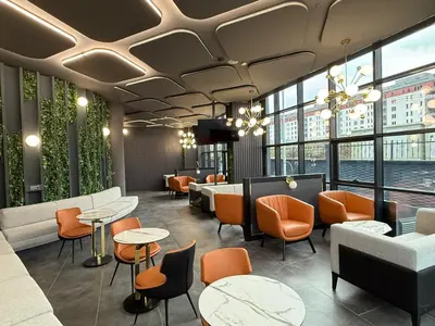 a restaurant with orange chairs and tables and windows at H-mak AIRPORT OTEL in Arnavutköy