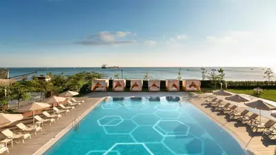 a swimming pool with lounge chairs and the ocean at Crowne Plaza Florya Istanbul by IHG in Istanbul