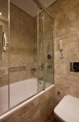 a bathroom with a shower and a tub and a toilet at Holiday Inn Istanbul - Kadikoy by IHG in Istanbul