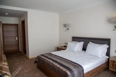 a bedroom with a bed with white sheets and pillows at The Life Nest Hotel in Saray