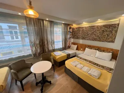 a bedroom with two beds and a desk and a table at The Rodin Taksim in Istanbul