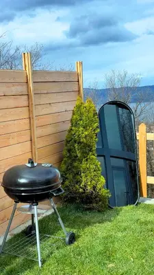 a grill sitting in the grass next to a fence at Dream River Sapanca in Sapanca