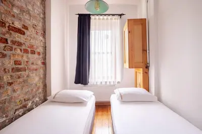 two beds in a room with a brick wall at Charming 2BD2Bath Galata Tower Unique Home! #409 in Istanbul