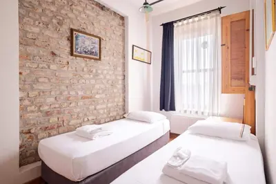 two beds in a room with a brick wall at Authentic Galata Tower Central 2BD2Bath Home #411 in Istanbul