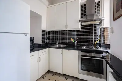 a kitchen with white cabinets and a sink and a stove at Authentic Galata Tower Central 2BD2Bath Home #411 in Istanbul