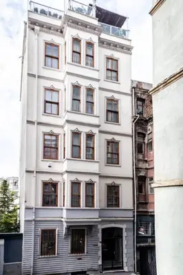 a white building with windows on a city street at Authentic Galata Tower Central 2BD2Bath Home #411 in Istanbul