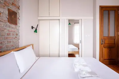 a bedroom with a white bed and a brick wall at Galata Tower 2BD2Bath Authentic Gem! #412 in Istanbul