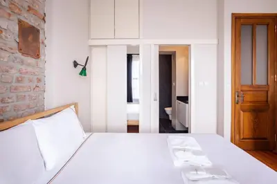 a bedroom with a white bed and a brick wall at Galata Tower 2BD2Bath Authentic Gem! #412 in Istanbul