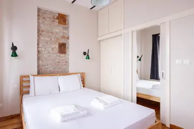 a bedroom with a white bed and a brick wall at Galata Tower 2BD2Bath Authentic Gem! #412 in Istanbul