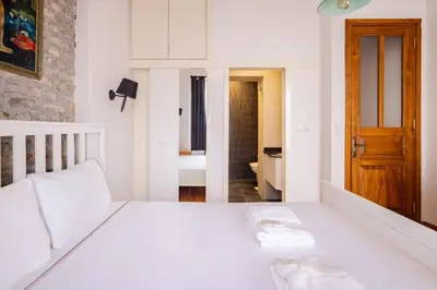 a bedroom with a white bed and a bathroom at Cozy Intimate 2BD2Bath Galata Tower Home! #410 in Istanbul