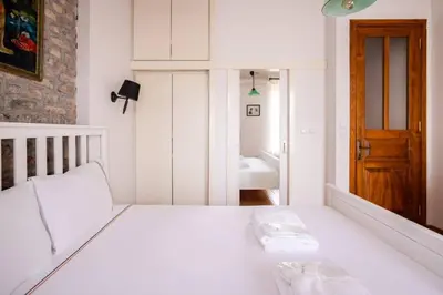 a white bedroom with a bed and a bathroom at Cozy Intimate 2BD2Bath Galata Tower Home! #410 in Istanbul