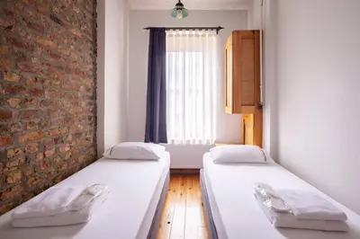 two beds in a room with a brick wall at Cozy Intimate 2BD2Bath Galata Tower Home! #410 in Istanbul