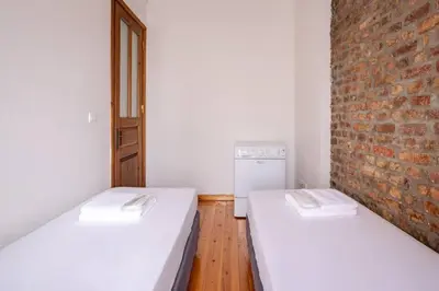 two beds in a room with a brick wall at Cozy Intimate 2BD2Bath Galata Tower Home! #410 in Istanbul