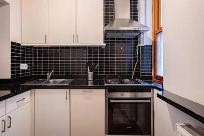 a kitchen with white cabinets and a sink and a stove at Cozy Intimate 2BD2Bath Galata Tower Home! #410 in Istanbul