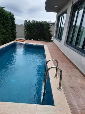 a swimming pool next to a house at Villa with private pool for daily rent in Istanbul in Buyukcekmece