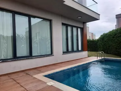 a house with a swimming pool next to a building at Villa with private pool for daily rent in Istanbul in Buyukcekmece