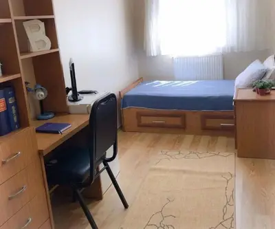 a bedroom with a bed and a desk with a computer at Akademik Pansiyon in Istanbul