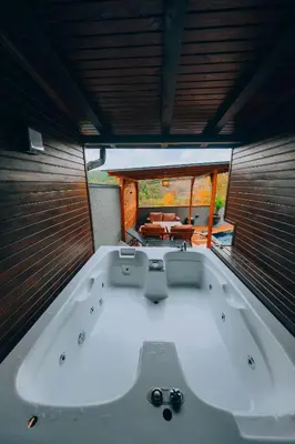 a large white bath tub in a room with a table at Sapanca Ruby Bungalow in Sapanca