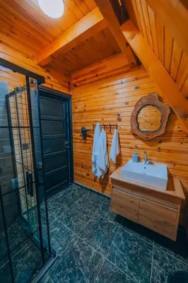 a bathroom with a sink and a wooden wall at Sapanca Ruby Bungalow in Sapanca